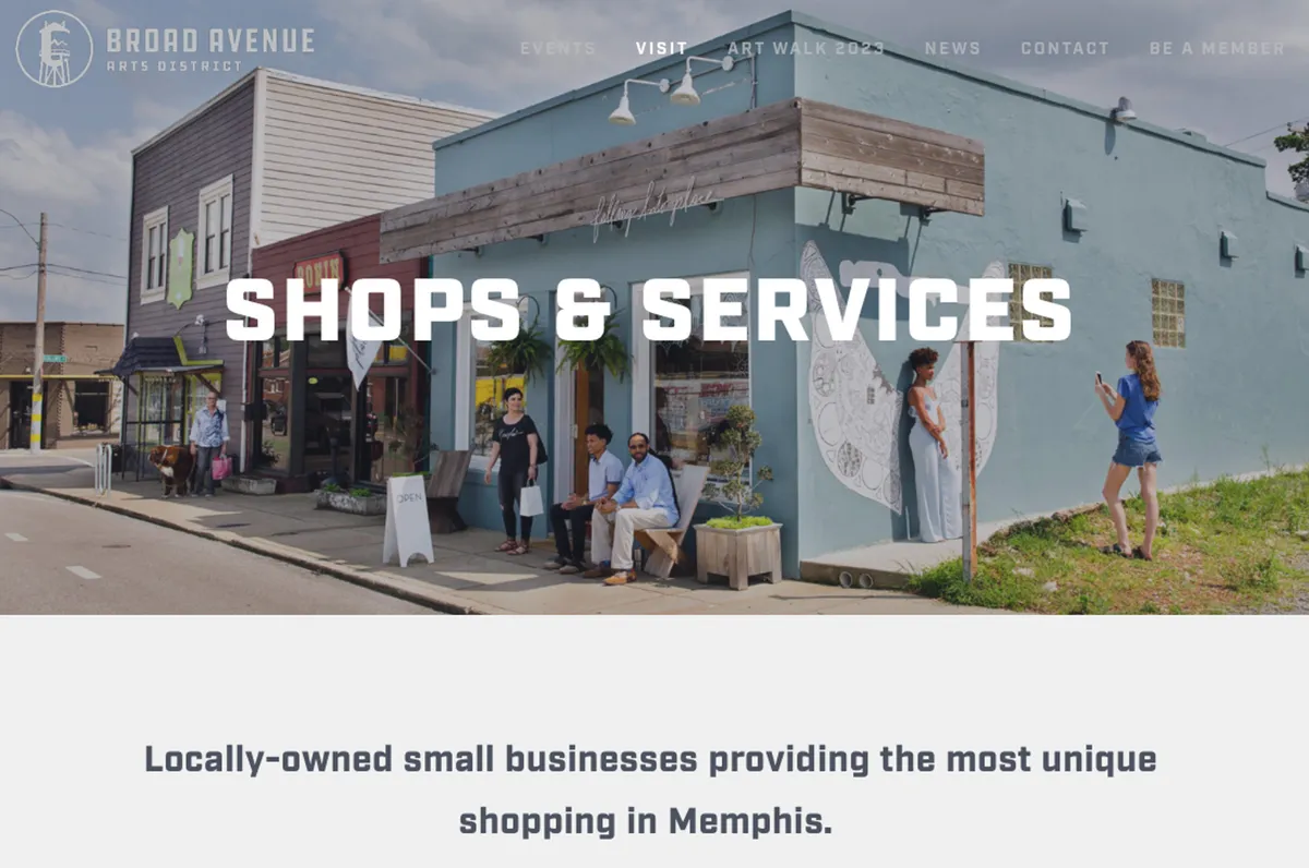 A lively streetscape of the Broad Avenue Arts District featuring colorful storefronts, vibrant murals on the building walls, and people engaging in various activities outside—shopping, chatting, and appreciating public art.